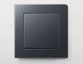Schwarzer Lichtschalter von JUNG mit glänzendem Rahmen auf heller Wand
