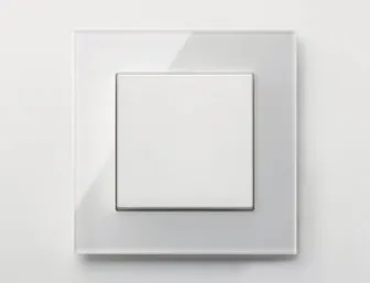 Weißer Lichtschalter von JUNG mit transparentem Rahmen auf heller Wand