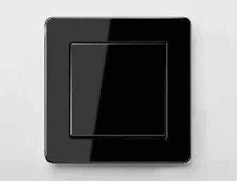 Schwarzer Lichtschalter von JUNG mit glänzendem Rahmen auf heller Wand