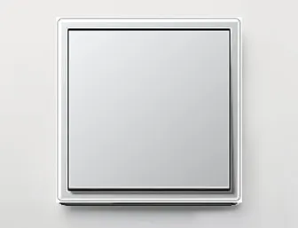 Silberner Lichtschalter von JUNG mit geradlinigem Rahmen auf heller Wand