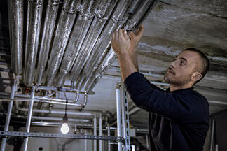 Handwerker mit Heizungsrohren 