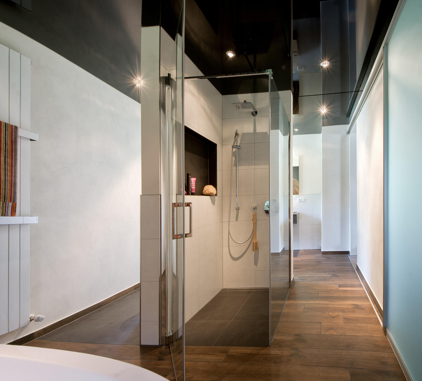 Moderne Dusche aus Glas in einem Bad mit Lackspanndecke